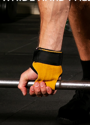 Person holding a barbell with yellow and black wrist support in a gym setting