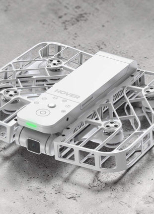 White drone with remote control on a gray surface